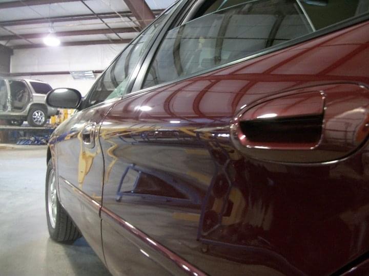 Maroon sedan rear door restored after paintless dent repair