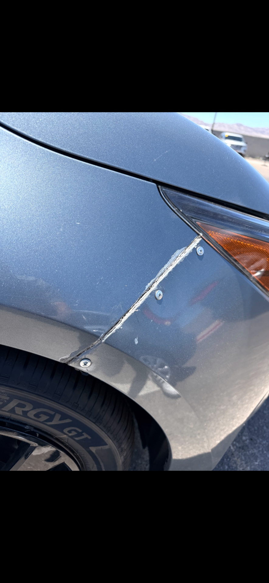 Gray sedan front fender with creased damage before body and paint repair